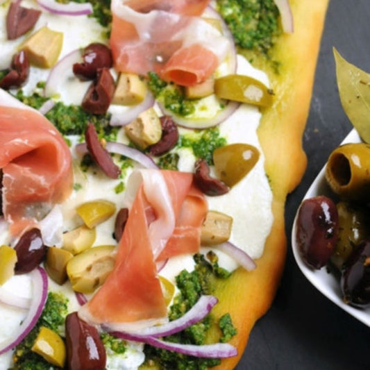 A colorful flatbread brimming with fresh, flavorful ingredients—creamy mozzarella, fragrant basil pesto, savory prosciutto and our stuffed Olives. 