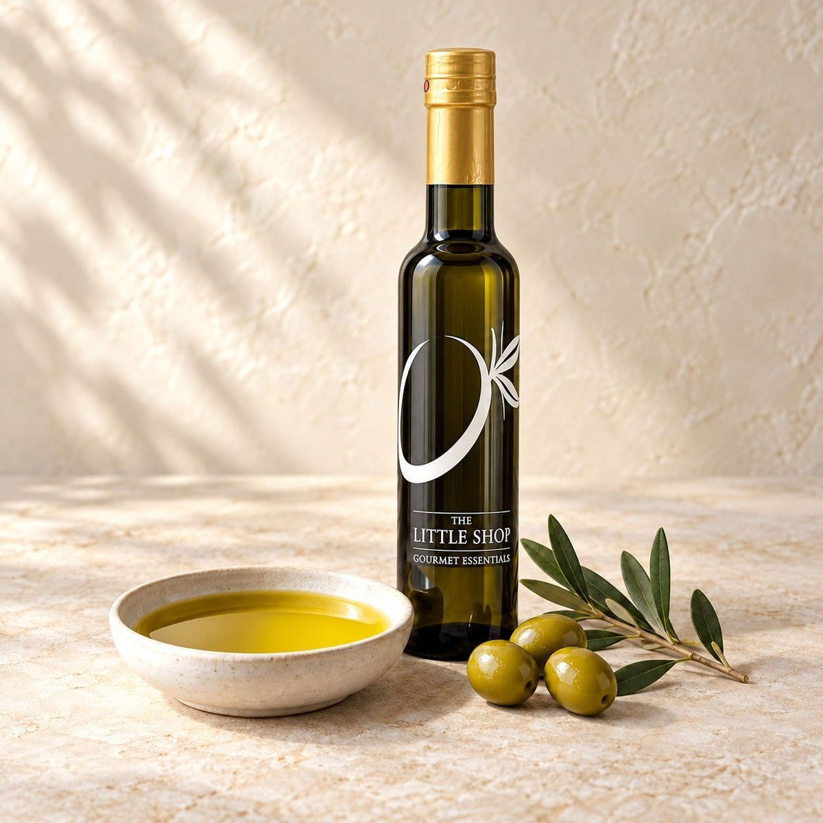 Premium dark and white balsamic vinegars and gourmet olive oil bottle from The Little Shop of Olive Oils with a ceramic dipping bowl and fresh olives