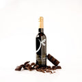 A bottle of gourmet balsamic vinegar with a gold foil top and a black label styled with broken dark chocolate pieces on a white background.