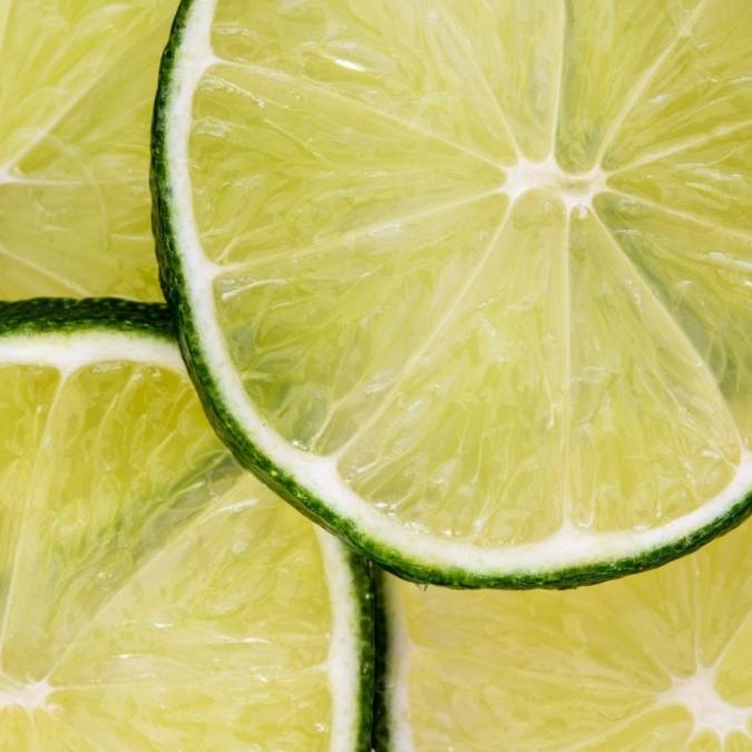 Close-up of overlapping lime slices showing the bright green-yellow pulp and dark green rind.