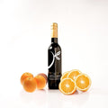 A bottle of Valencia orange olive oil by The Little Shop, styled with whole and sliced oranges on a clean white background.