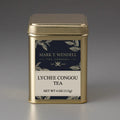 Gold tea canister labeled 'Lychee Congou Tea' by Mark T. Wendell on a gray background